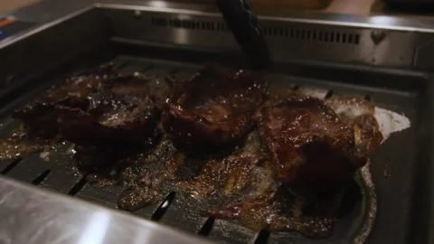 Close-up shot of restaurant chef flipping juicy meat steak with metal tongs Stock Footage 155705571