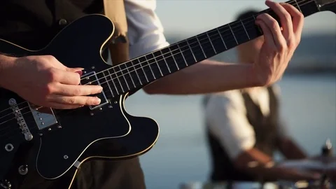 Close up shot of the rhythm guitar, a man plays with the help of a mediator Stock Footage