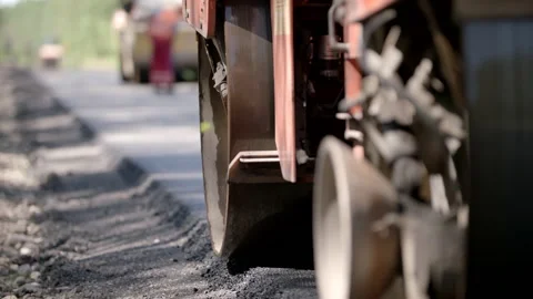 Close-Up Shot Of A Road Roller Driving On A Tarmac Road In A Forest Stock Footage 142000600