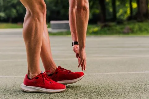 Close-up shot of a runner touching toes to warm up before training Foto stock