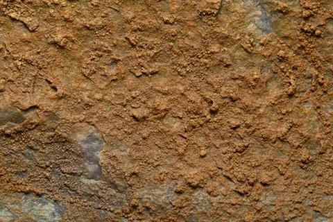 A close up shot of an rustic orange rock. Stock Photos