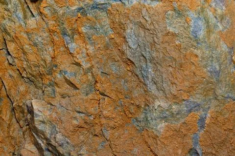 A close up shot of an rustic orange rock. Stock Photos