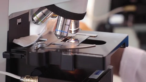 Close-up shot of sample slide and microscope with metal lens at laboratory Stock Footage 127285267