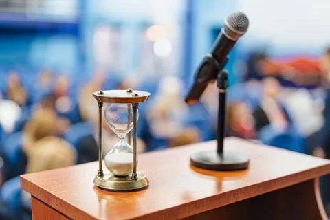 Close-up shot of an sand clock next to a microphone Stock Photos