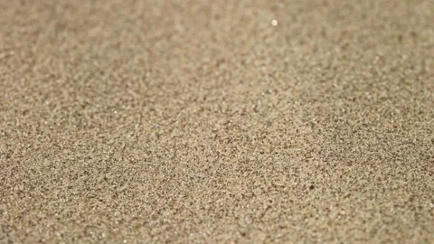 Close-up shot of sand. The texture of sand, grains of sand fly blown away by the Видео 252967615