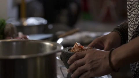 Close up shot of scooping smashed ingredients from stone mortar in slow motion Stock Footage 146250171