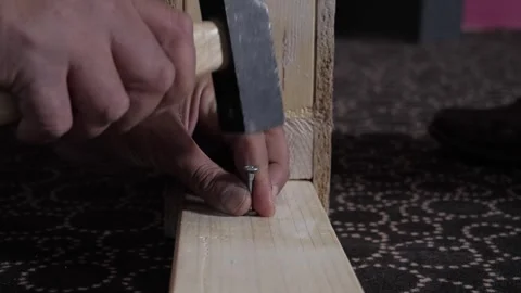 Close-up shot of a screw being hammered and screwed into wood to secure Stock Footage 290766228