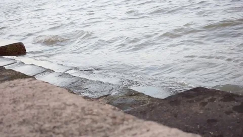 Close-up shot of sea wave splashing over the harbour plain built Stock Footage 93594841