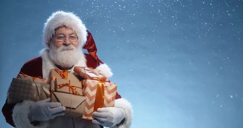 Close up shot of senior bearded man in santa clause outfit carrying gift boxes Stock Footage 117801191
