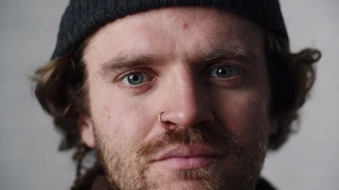 Close up shot serious young guy in cap. Blue eyes man with piercing in nose Stock Footage 263708561