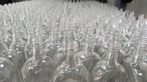 A close-up shot of a set of six empty glass bottles arranged on an assembly.. Stock Photos
