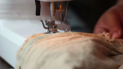 Close up shot of sewing machine sewing a light brown fabric Stock Footage 68013447