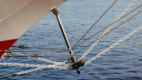 A close-up shot of a ship bow with white rigging chains and metal ropes ove.. Stock Photos