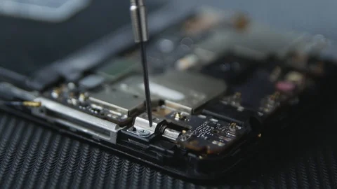Close-up shot showing the process of cell phone repairing. Hands of repairer  Stockbeeldmateriaal 113398505