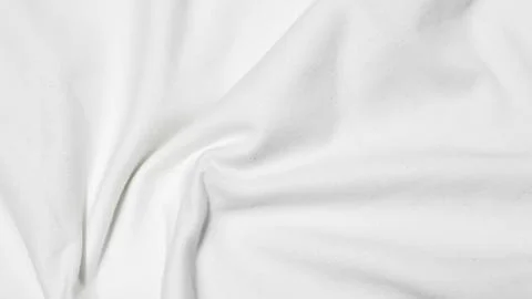 Close up shot showing the subtle texture and soft folds of a white fabric sur Stock Photos