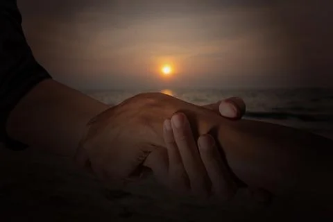 A close-up shot showing two hands clasped in a supportive gesture against t.. Stock Photos