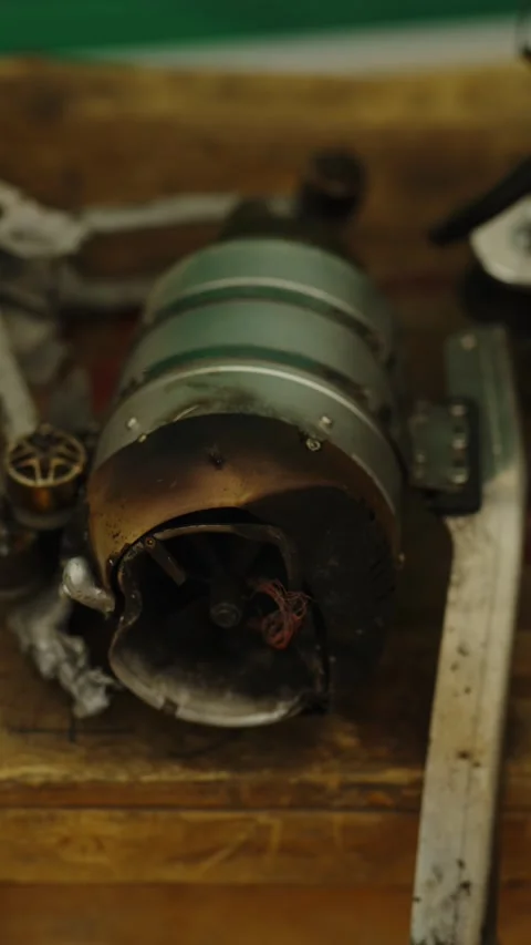 A close-up shot shows a burnt and damaged micro turbojet engine resting Vidéo 339910624