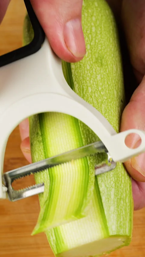 A close-up shot shows a chef slicing a fresh green zucchini. Stock-Footage 342285371