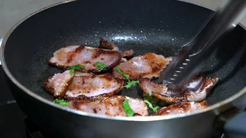 This close up shot shows fresh bacon cooking and sizzling in cast iron pan. 스톡 동영상 334642282