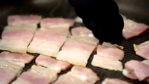 This close up shot shows fresh bacon cooking and sizzling in cast iron pan. 스톡 동영상 334642429