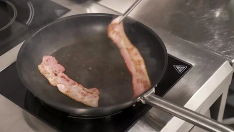 This close up shot shows fresh bacon cooking and sizzling in cast iron pan. 스톡 동영상 334642481