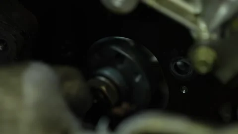 A close-up shot shows a mechanic's gloved hand reaching into a deep, dark ope Stock Footage 345109656