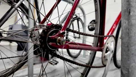 A close-up shot shows a red bicycle with a rusty chain and spokes secured in a Video stock 327830460