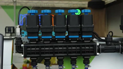 A close-up shot shows a section control valve manifold with blue caps Stock Footage 339910911