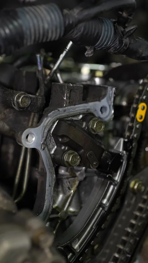 A close-up shot shows a socket wrench tightening bolts on a metal engine comp Stock Footage 345107701