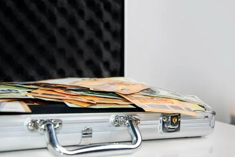 A close-up shot of a silver briefcase lying open on a white surface, revealin Stock Photos
