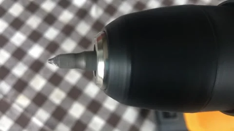 A close-up shot of the silver metal Phillips head screw bit and black chuck.. Vídeo Stock 323210882