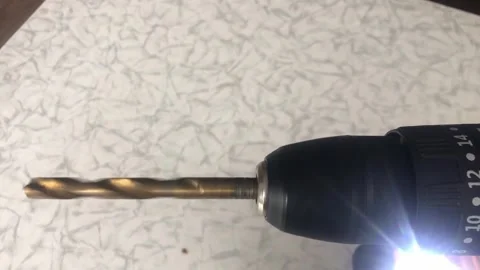 A close-up shot of the silver metal Phillips head screw bit and black chuck.. Vídeo Stock 323215485