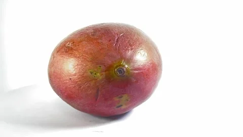 A close-up shot of a single, ripe, oblong mango fruit with smooth, textured.. Vídeos de archivo 323738731