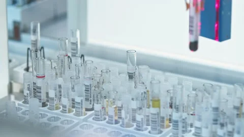 Close shot of a single test tube in a holder moving along the line of an Stock Footage 232687136