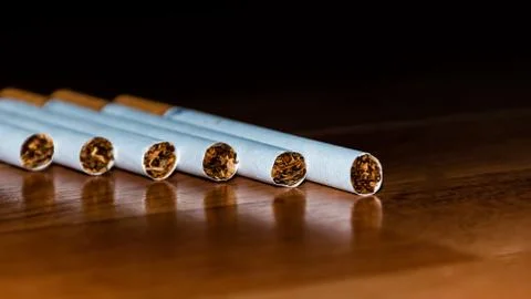A close-up shot of six cigarettes lying on the table Stock Photos