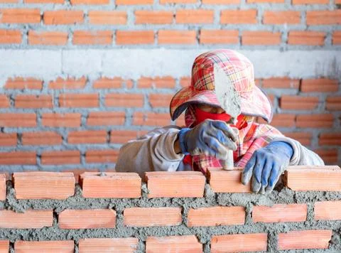 A close-up shot of a skilled mason at work on a construction site, using to.. Stock Photos