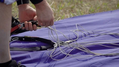 Close up shot of a skydiving instructor packing, preparing equipment for the Stock Footage 94952796