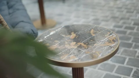 Close-up shot with a slight push-in on a round marble side table with a brass Stock Footage 333675620