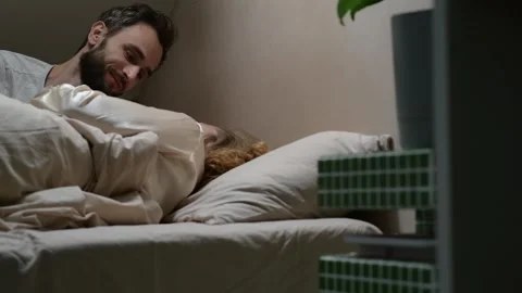 Close up shot from slightly low angle of a young married couple lying in bed. Vidéo 329939733