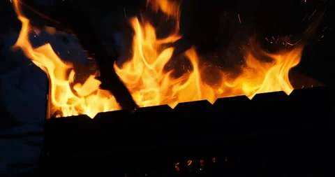 Close up shot in slow motion of a large bright red fire in a barbecue bbq grill 動画素材 132179101