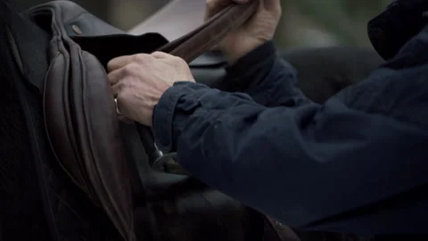 Close shot in slow motion of a man adjusting the seat of a horse. Stock Footage 219471350