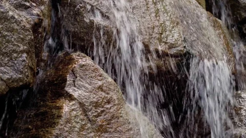 Close-up shot of a small waterfall between wet rocks Stock Footage 283567338