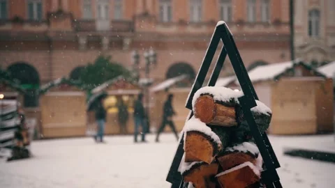 A close-up shot of snow-covered logs against the backdrop of a Christmas market Stock Footage 167449149