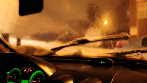 Close up Shot Of Snowdrops Dropping On Car Windshield At Night. Stockbeeldmateriaal 169416826