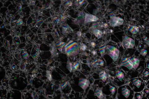 Close-up shot of soap bubbles with light interference patterns on a black backgr Stock Photos