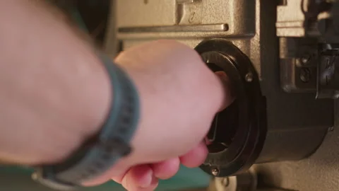 In a close-up shot, someone powers down an antique movie projector, captured by Stock Footage 267613349
