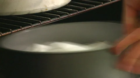 Close Shot of Someone Putting a Cake in the Oven Stock Footage 55666862