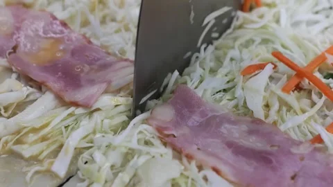 Close-up shot of a spatula cutting into a savory Japanese Okonomiyaki pancake wi Stock Footage 331956129