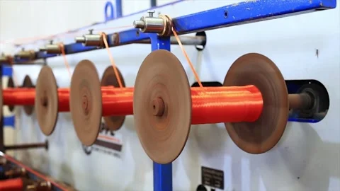 Close up shot of Spool of Bright Orange Thread winding machine Stock Footage 317982812