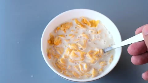 Close-up shot of a spoon lifting a portion of golden cornflakes soaked in f.. Stock Footage 302701212